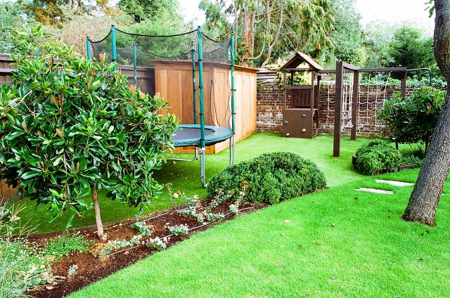 Children's play area with playframe, astroturf and bespoke western red cedar cupboard