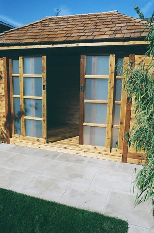 Western red cedar summer room with cedar shingle roof and glass sliding doors